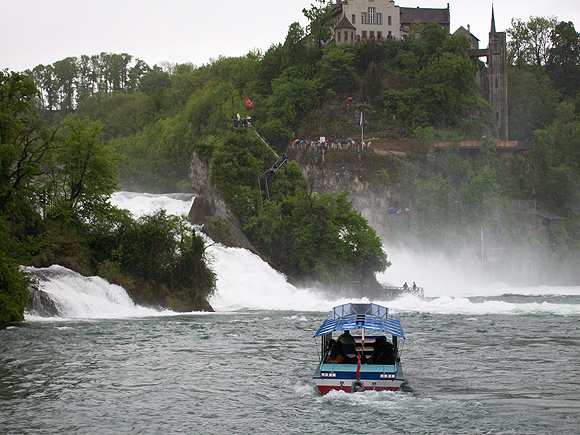 Ansicht vom Neuhausener Ufer (Bootsanleger) mit dem Felsen und Schloss Laufen. Touristenboot