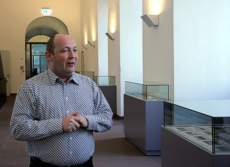 Der Sammler Alexander Wischniewski vor den Virtrinen mit den von ihm zusammengetragenen Schätzen