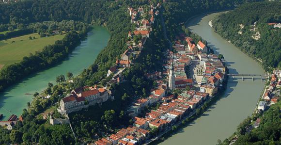 Burghausen an der Salzach, Luftbild mit Burg und Stadt. 1051 Meter erstreckt sich die Anlage über der Altstadt rechts und dem Wöhrsee links. Die Brücke über die Salzach verbindet Bayern und Österreich. © Stadt Burghausen und Burghauser Touristik GmbH