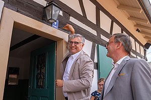Staatssekretär Arne Braun (links) und Landrat Frank Scherer (rechts) brachten gemeinsam die Hausnummer des Ortenauhauses bei seiner Eröffnung im Freilichtmuseum Vogtsbauernhof am Sonntag, den 2. Juli, an. Foto: Schwarzwälder Freilichtmuseums Vogtsbauernhof, Benedikt Spether