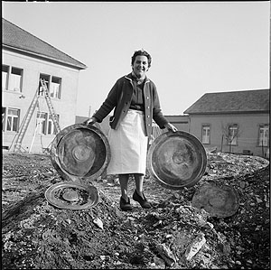 Die Wirtin des Restaurants Zum Löwen miz zwei antiken Silbertabletts.